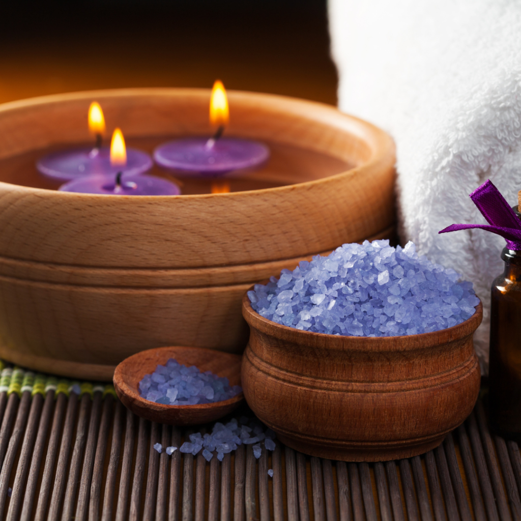 Espaço de autocuidado com vela aromática, toalha e música suave para fazer escalda-pés.